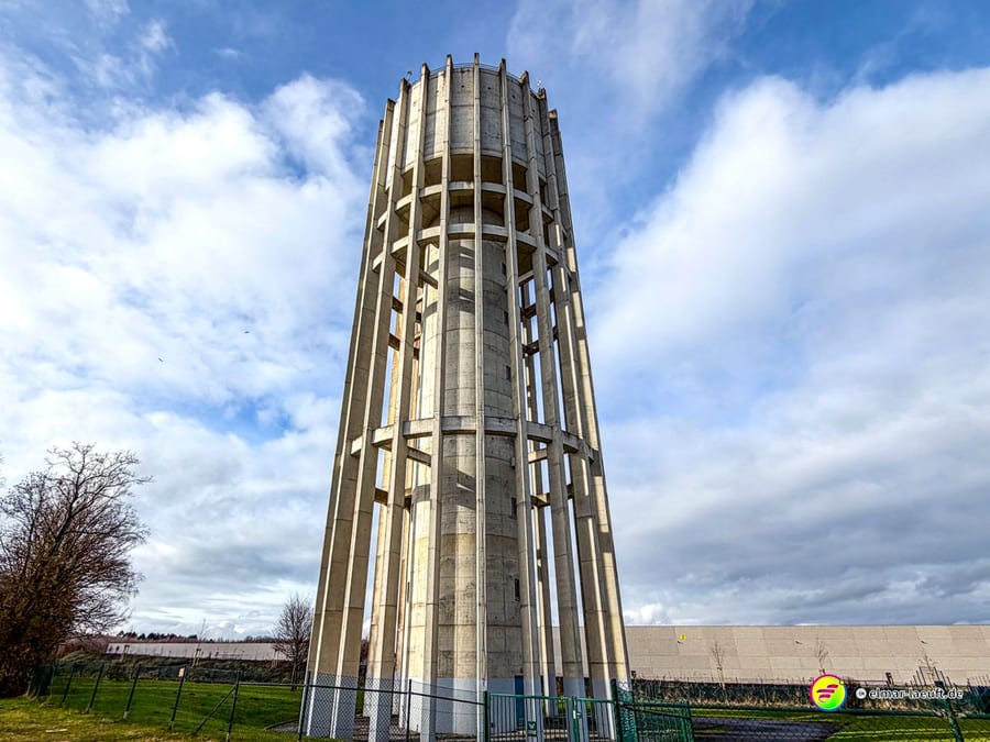 Moderner Wasserturm in skelettartiger Betonarchitektur mit zylindrischem Reservoir. Die offene Konstruktion mit vertikalen Betonstreben zeigt typische Ingenieurbauweise der Nachkriegszeit.