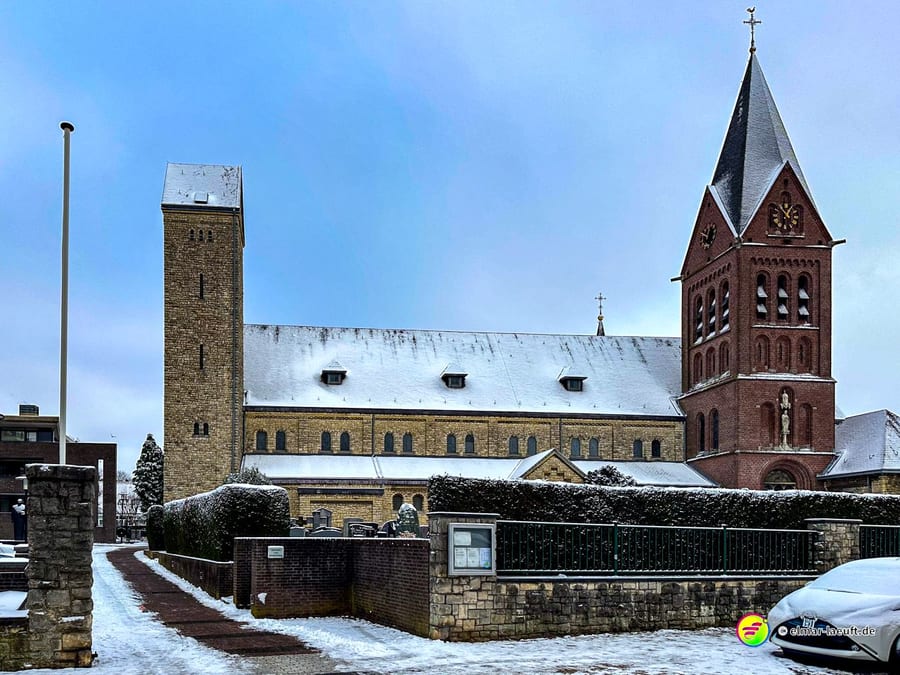 Laufen in Heerlen auf verschneitem Weg mit Blick auf eine große Kirche und winterliche Umgebung.